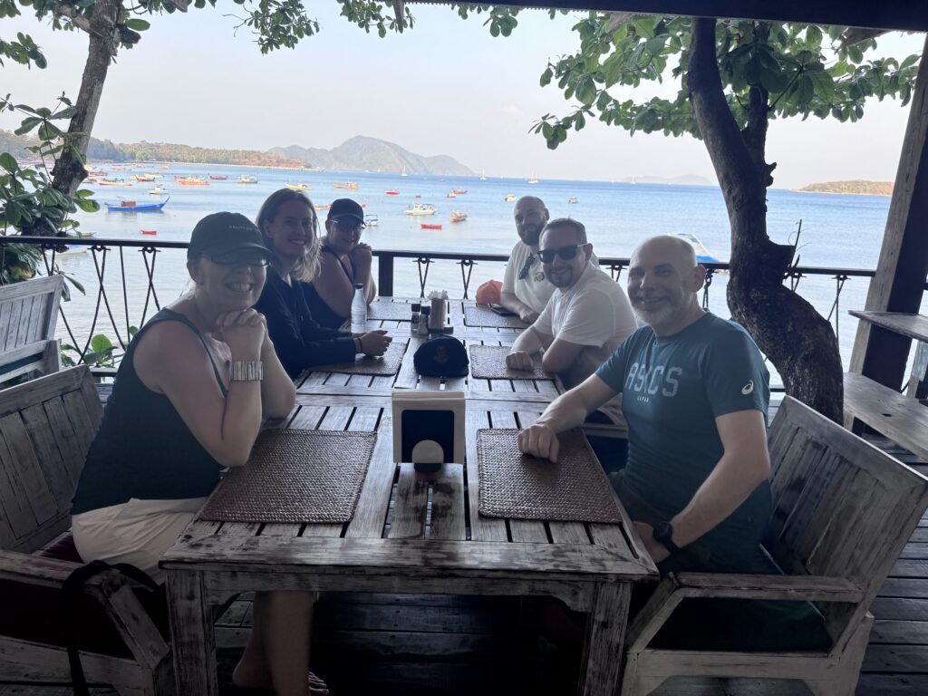 Friends sharing a meal beside the sea